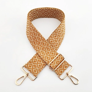 Detail of adjustable woven bag strap featuring an orange and beige geometric diamond pattern