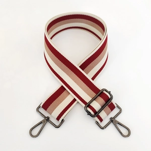 Detail of red and beige striped wide canvas strap with dark gunmetal swivel hooks