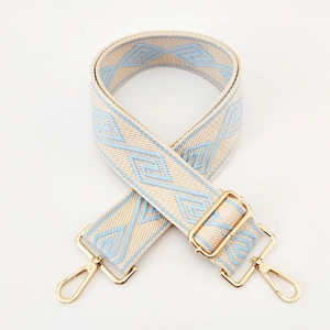 Detail of blue and beige geometric diamond pattern on wide woven adjustable bag strap