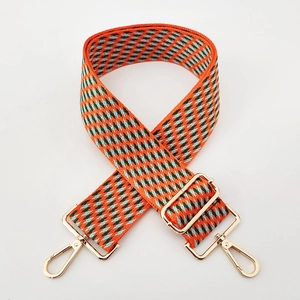 Detail of adjustable 5cm wide jacquard embroidered bag strap with golden metal swivel hooks