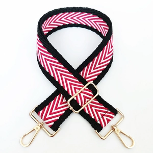 Detail of red and white chevron woven strap with adjustable gold metal buckle and lobster clasp