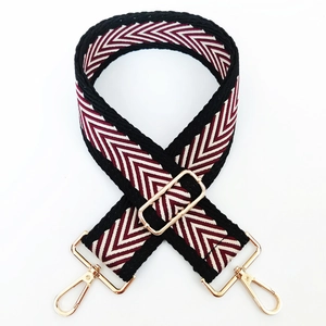 Detail of red and white chevron wide woven strap with premium gold metal hardware