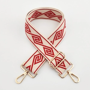 Detailed view of red and beige geometric pattern weaving on wide canvas shoulder bag strap