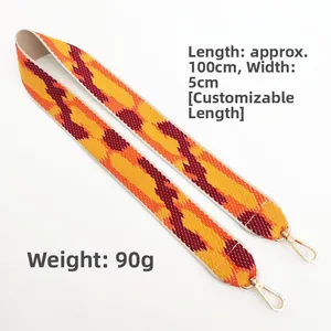Close-up of colorful woven shoulder strap with gold metal hooks and dimension markings