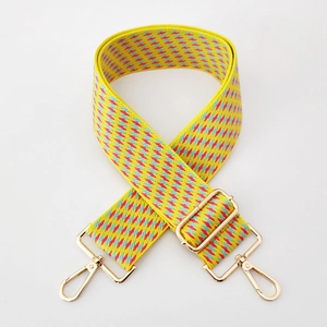 Detail showing colorful geometric jacquard weaving and gold metal buckle on 5cm bag strap