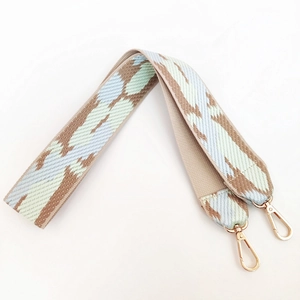 Detail of colorful geometric woven bag strap with golden metal lobster clasps