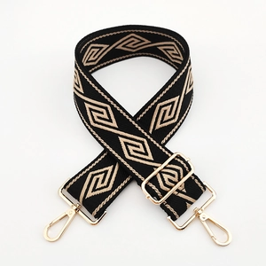 Detail of geometric pattern woven bag strap with golden metal swivel hooks and buckles