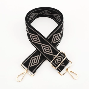 Close-up of wide geometric pattern shoulder strap with gold metal hooks and adjustable buckle