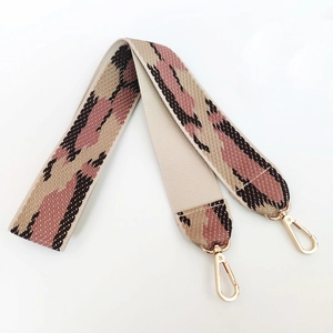 Detail of colorful geometric wave pattern woven wide bag strap with gold metal lobster clips