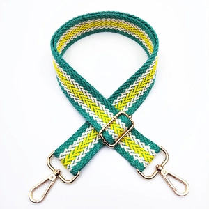 Close-up of colorful green, yellow and white chevron woven strap with gold metal hardware