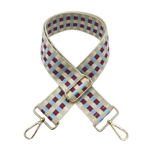 Close-up of checkered retro shoulder strap with beige, red, blue weave and gold metal hooks