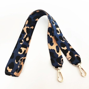 Detail eines breiten Schultergurts mit Leopardenmuster und goldenen Karabinerhaken
