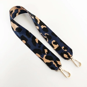 Detail eines breiten Schultergurts mit Leopardenmuster und goldenen Karabinerhaken