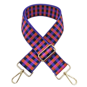Close-up of adjustable wide woven bag strap with colorful purple and orange checkered pattern