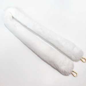 Close-up of fluffy white faux fur bag strap with polished gold-toned metal spring buckles