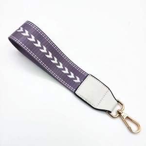 Detail of purple and white woven wrist strap with arrow pattern and gold lobster clasp