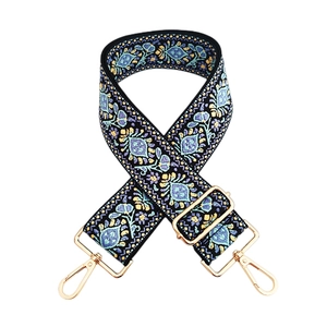 Close-up of floral embroidery pattern and gold metal buckle on a colorful woven strap