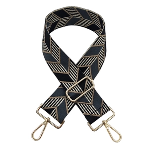 Close-up of adjustable woven shoulder strap with geometric pattern and gold buckles