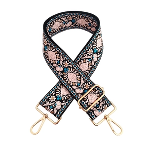 Detail of bohemian floral embroidery on wide adjustable shoulder strap with gold hardware