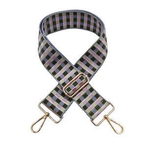 Macro view of adjustable checkered bag strap with purple-green pattern and gold hardware