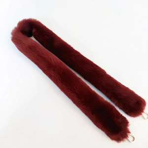 Detail of burgundy faux fur handbag strap with gold metal lobster clasps
