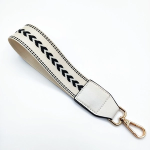 Close-up of wide woven wristlet strap with chevron pattern and gold lobster clasp
