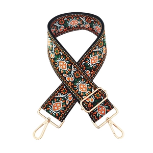 Close-up of thick ethnic embroidered bag strap with orange geometric patterns and gold clips