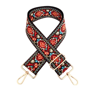 Detail of bohemian ethnic embroidered wide bag strap with golden metal swivel hooks