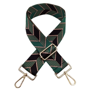 Detail of adjustable woven canvas strap with green geometric pattern and gold buckles