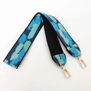 Detail showing the thick blue and green woven geometric pattern on wide handbag strap
