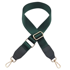 Close-up of forest green nylon strap with gold hardware and black leather connectors