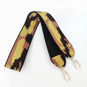 Close-up of geometric weaving pattern and golden lobster clasps on wide bag strap