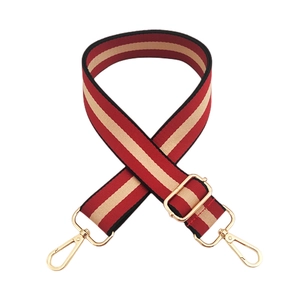 Détail de la bandoulière tissée à rayures rouges et beige avec boucles en métal doré
