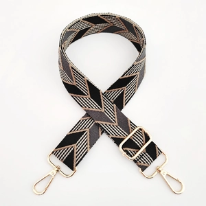 Close-up of geometric arrow pattern woven strap with gold metal hooks for handbags