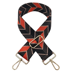 Detail of adjustable wide canvas bag strap with orange and black geometric chevron patterns