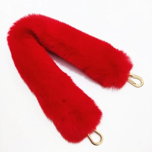 Detail of red faux fur replacement strap for bags with polished gold metal buckles