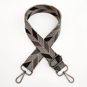 Detailed view of woven geometric strap with gunmetal grey swivel hooks and buckle