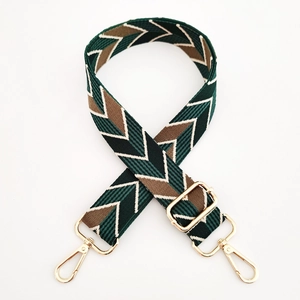 Close-up of jacquard zigzag strap with gold metal swivel hooks and adjustable buckle