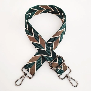 Detail of adjustable woven purse strap with green and brown diamond geometric patterns