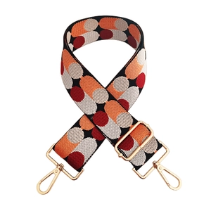 Detail of colorful jacquard woven strap with golden swivel hooks and adjustable buckle