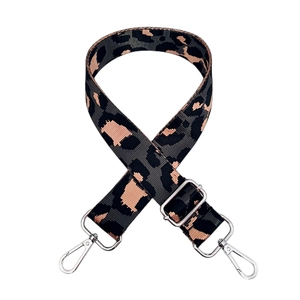 Macro detail of leopard jacquard wide strap with silver swivel hooks and adjustable buckle