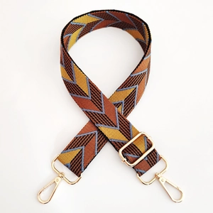 Close-up of geometric jacquard shoulder strap with gold-tone swivel lobster clasps