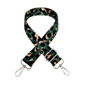 Detailed view of green leopard print nylon bag strap with shiny silver metal buckles