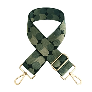 Close-up of green polka dot jacquard bag strap with adjustable gold-toned metal hooks