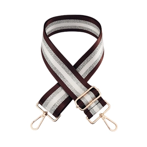 Detail of adjustable nylon striped bag strap with rose gold metal hooks and silver wire weave