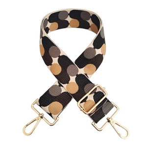 Close-up of jacquard woven strap with vintage polka dots and gold metal buckles