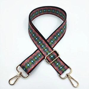 Close-up of ethnic geometric embroidery on adjustable strap with gold metal hooks