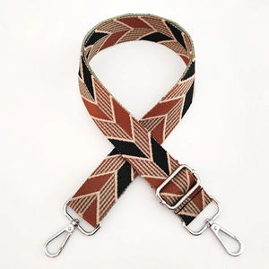 Close-up of adjustable wide woven bag strap with brown chevron pattern and silver buckles