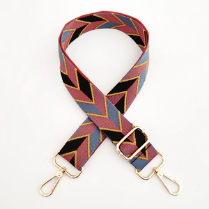 Detail of colorful geometric woven bag strap with golden metal swivel hooks and adjuster