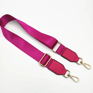 Macro detail of magenta nylon replacement bag strap with golden metal lobster clasps